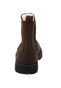 Brązowe skórzane botki za kostkę z czarnymi gumowymi podeszwami i elastycznymi bocznymi panelami, z miękkim wnętrzem dla komfortu i detalami logo na boku.