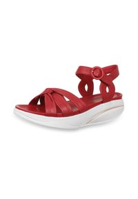 Sandale ouverte en cuir rouge avec détail noué, bride de cheville ajustable, et semelle épaisse blanche coussinée avec un léger talon.