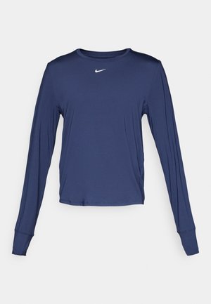 Tumed pikka varrukaga sportlik särk, mis on valmistatud kergest kangast, ümmarguse kaelusega ja väikese valge logoga rinnal.