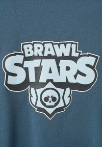 Material albastru care afișează logo-ul „BRAWL STARS” în negru și alb, cu un grafic de craniu în interiorul unui contur decorativ în formă de scut.