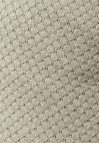 Tissu texturé beige avec un motif en losange ; présente de petits trous et une apparence tricotée. Texture lisse avec un design respirant.