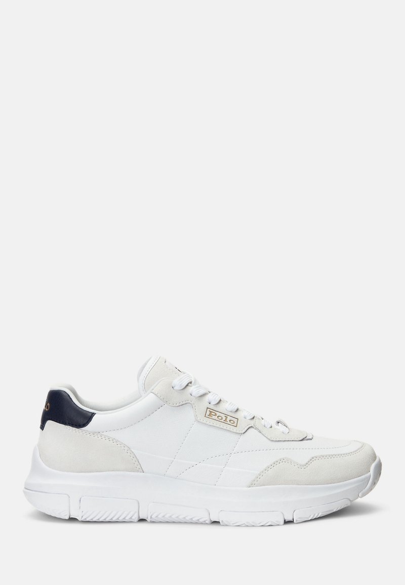 Vit sneaker i slätt läder med mockadetaljer och marinblå häl. Har en vadderad krage och en texturerad gummisula för bra grepp.