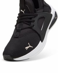 Baskets Puma noir et blanc avec tige en mesh, semelle rembourrée et logo Puma sur l’orteil, la languette et le panneau latéral.