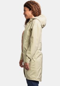 Helle beige, wasserdichte Jacke mit Kapuze, seitlichen Taschen und orangefarbenen Reißverschlussakzenten, die ein glattes, elegantes Design präsentiert.
