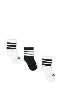 Tres pares de calcetines tobilleros: uno negro con rayas blancas, dos blancos con rayas negras. Textura suave, material de mezcla de algodón con canalé.