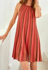 Robe sans manches en ligne A avec des rayures horizontales dans des tons rouges et bruns, dotée d'un col montant et d'un tissu léger et texturé.