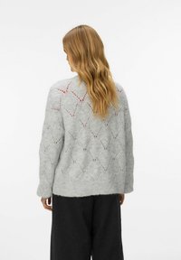 Grauer gestrickter Pullover mit lockerem Schnitt, der ein Rautenmuster und subtile rote Akzente aufweist, aus einem weichen, strukturierten Material gefertigt.