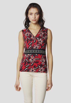 Rotes ärmelloses Oberteil mit floralem Muster in Schwarz und Weiß, mit V-Ausschnitt und schwarzem Bundakzent an der Taille.