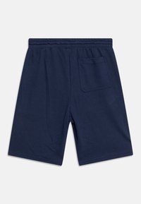 Tmavě modré šortky vyrobené z měkké látky, s elastickým pasem a jednou kapsou na zadní straně. Hladký povrch s volnějším střihem.