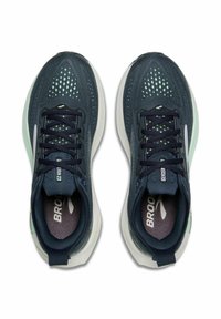 Blauwe en groene sportschoenen met een ademende mesh bovenkant, reflecterende accenten en een wit dempend zooltje met veters.