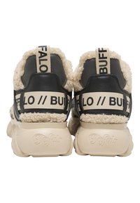 Een paar zwarte en crèmekleurige sneakers met dikke zolen, beige fleece voering en beige bandjes met de tekst "BUFFALO" op de hiel- en tonglabels.