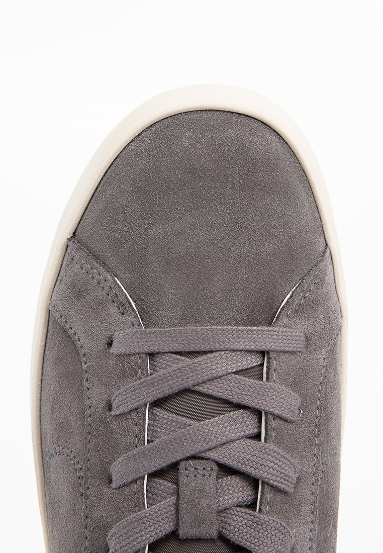 Grijze suède sneaker met een ronde neus, textuurveters en een crèmekleurige rubberen zool. Schoon ontwerp met minimale stiksels en geen patronen.