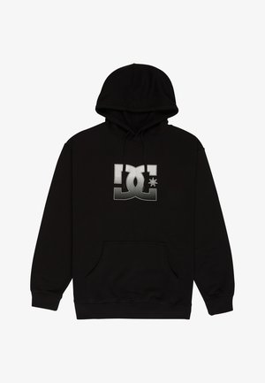 Czarna bluza z kapturem z bawełnianego materiału, z dużym białym logo DC z gwiazdką. Zawiera przednią kieszeń typu kangur i sznurki do regulacji kaptura.