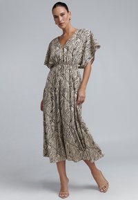 Bež krūzveida kleita ar melnām zebras svītrām, V veida izgriezums, īsas piedurknes un aizdare ar auklu viduklī. Viegls audums ar plūstošu siluetu.