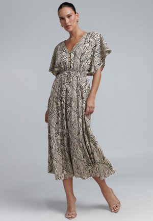 Garšs, brīvi krītošs kleita gaiši pelēkā krāsā ar melnām zebras svītrām. V-veida kakls, īsas piedurknes un savilktā josta ar pogu akcentiem. Gluda tekstūra.