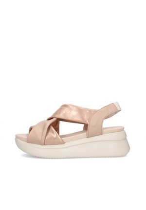 Sandalo con zeppa beige da donna con cinturini incrociati, punta aperta, cinturino posteriore e suola bianca spessa su sfondo bianco.