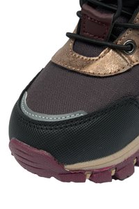 Ciemnobrązowe i czarne sneakersy z teksturowaną cholewką, mosiężnymi akcentami, odblaskowymi detalami oraz solidną bordową gumową podeszwa.