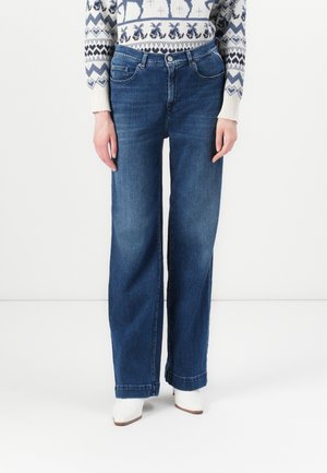 Wide-leg blue jeans made of denim with a smooth texture, featuring a classic five-pocket design and stitched detailing, paired with white shoes.