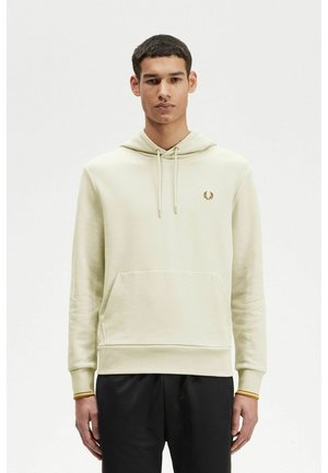 Sudadera verde claro de tela suave con bolsillo canguro. Presenta un logo bordado en dorado en el pecho y puños elásticos con detalles de acento.