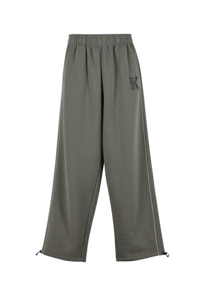 Luźne spodnie dresowe w oliwkowym kolorze ze ściągaczem w pasie, małym czarnym logo "K" na lewej udzie oraz regulowanymi sznurkami przy nogawkach.