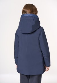 Giubbotto imbottito blu navy con ampio cappuccio, caratterizzato da un colletto testurizzato e un orlo dritto. Materiale liscio e leggero visibile sul retro.