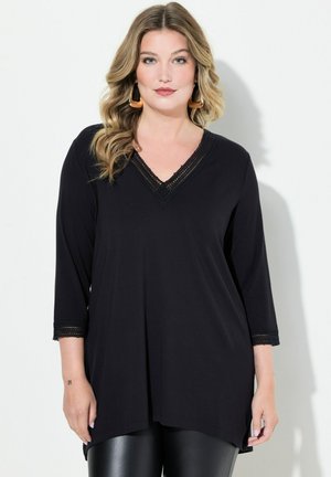 Zwart long-sleeve top met een V-hals, versierd met kanten rand langs de hals en mouwen, gemaakt van een zachte, lichte stof.