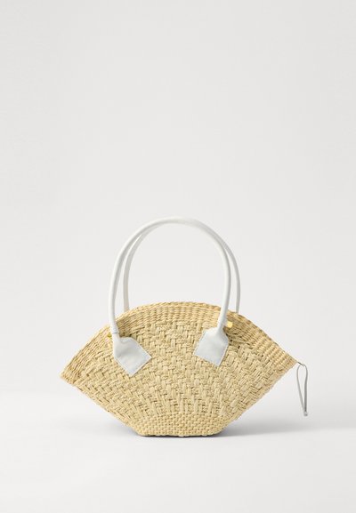 Woven straw handbag with a fan shape, white leather accents, and rounded handles. Features a textured surface and a zip closure.