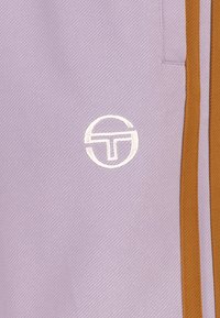 Tessuto lilla con trama diagonale, caratterizzato da strisce laterali marroni e un logo ricamato bianco centrato in fondo.