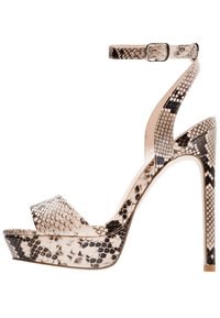 Sandale à talons hauts avec une sangle à la cheville, présentant un design en imitation serpent beige et noir. Semelle plateforme et texture lisse.