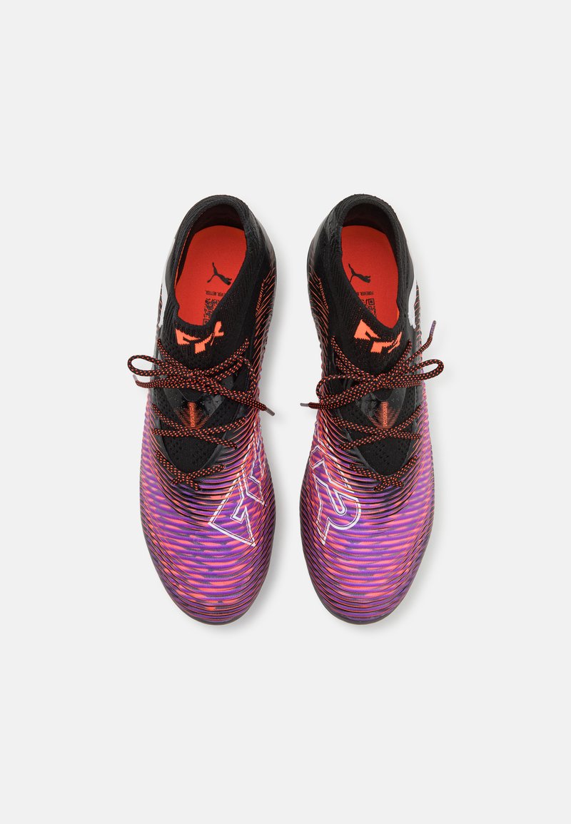 Botas de fútbol negras y rosas con una parte superior texturizada, que presentan un vibrante patrón de olas, cordones negros y un logo en el lateral.