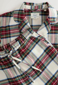 Rød, grøn og kremfarvet plaid bomulds pyjamas sæt med en kravebetonet top og bukser med snoretræk, der har en blød tekstur og rutemønster.