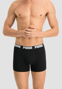 Black boxer briefs featuring a stretchy waistband with "PUMA" logo in white. Soft material, fitted design for comfort and support.