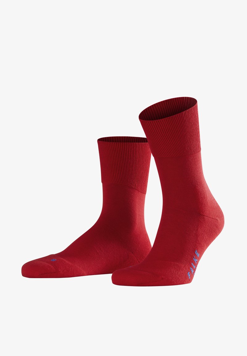 Spilvena spilgti sarkana vidukļa zeķes ar ribotām aprocēm un zilu "FALKE" zīmolu sānos, attēlotas uz baltas fona.