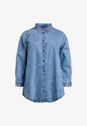 Svijetloplava traper košulja s dugim rukavima i dugmadi sprijeda, ukrašena izvezenim cvjetnim detaljima. Ima klasičnu kragnu i ležeran kroj.