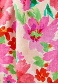 Tela floral con grandes flores rosas, rojas y verdes sobre un fondo beige claro; textura suave con acuarelas vibrantes.