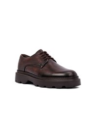 Zapatos de cuero marrón con cordones y acabado texturizado, punta redondeada y suela gruesa y resistente que presenta un diseño de dibujado en suela.
