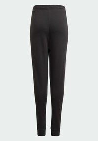 Pantalones de chándal negros hechos de una tela suave, con un diseño ajustado, cinturilla elástica y puños entallados en los tobillos. Sin logotipos visibles.