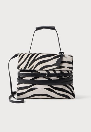 Sac à main rayé zèbre noir et blanc avec poignée supérieure, bandoulière réglable et deux ceintures noires à boucles sur le devant.