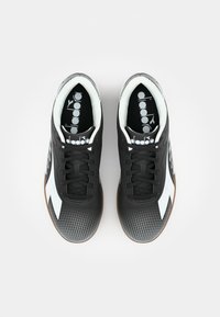 Black athletic shoes featuring white accents and a textured design, with a patterned toe box and rubber sole. Laces are black.