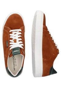 Braune Wildledersneaker mit weißen Schnürsenkeln, Gummisohle, grünen Akzenten an der Ferse und einer strukturierten weißen Zwischensohle. Branding ist innen sichtbar.