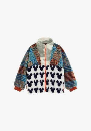 Fleecejacke mit blau-braunen karierten Ärmeln und Oberkörper, cremefarbenem und grauem Kragen sowie weißem Frontpanel mit Muster schwarzer Mickey-Mouse-Köpfe.