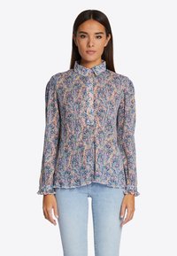 Bluza s cvjetnim uzorkom u višebojnom materijalu, sa dugim napuhanim rukavima, ovratnikom i nabranim manžetama. Donji rub je blago zakrivljen.