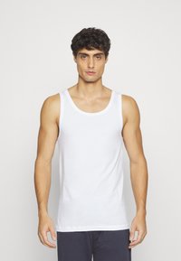 Top de tirantes blanco de algodón con escote redondo y tirantes anchos, que presenta una textura suave y un diseño ajustado.