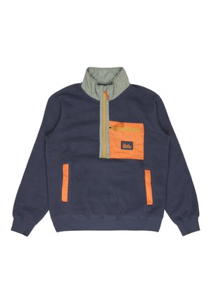 Granatowy polar z zielonym kołnierzem. Posiada pomarańczową kieszeń na piersi zapinaną na zamek oraz pomarańczową boczną kieszeń, z teksturowanym wykończeniem.