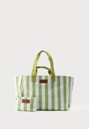 Sac cabas rayé et petite pochette assortie en blanc avec des rayures verticales vertes et vert foncé, avec des anses vertes et des étiquettes de marque marron.