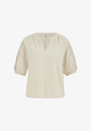 Blouse couleur crème avec des manches bouffantes jusqu'au coude, des détails floraux brodés sur les manches, et un petit col en v.