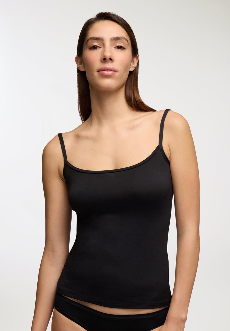 Camisetta nera aderente con spalline sottili e scollatura rotonda, realizzata in tessuto liscio e elasticizzato, ideale per essere indossata a strati o per un look casual.