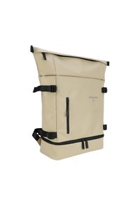 Světle hnědý batoh s rolovacím víkem vyrobený z voděodolného materiálu. Obsahuje černé popruhy, přední kapsu na zip a minimální logo.