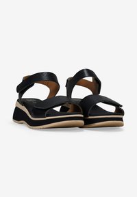 Sandalias negras con textura, de tiras anchas, punta abierta y suelas de cuña beige con acentos en negro y blanco. Tiras ajustables para un mejor ajuste.