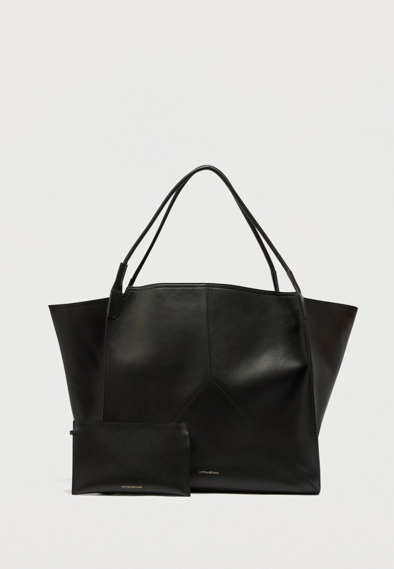 Sac cabas en cuir noir avec doubles poignées et petite pochette assortie, les deux avec un logo doré discret sur un fond uni.
